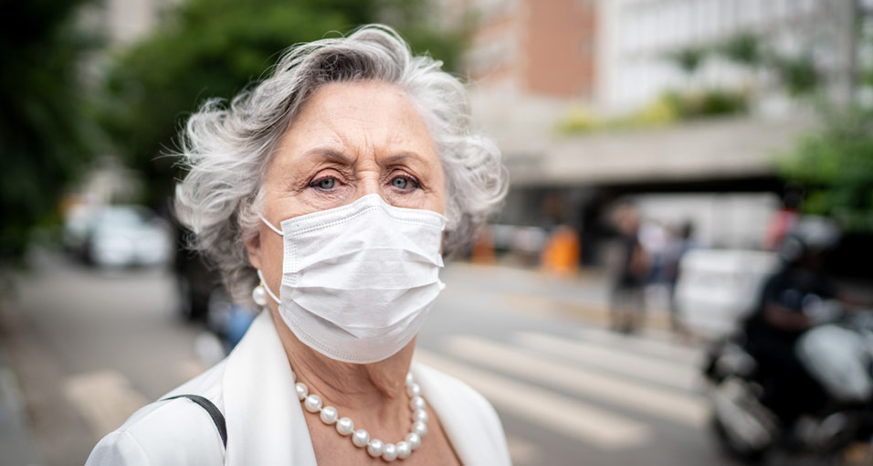 Ältere Frau mit Maske zum Schutz vor dem Coronavirus